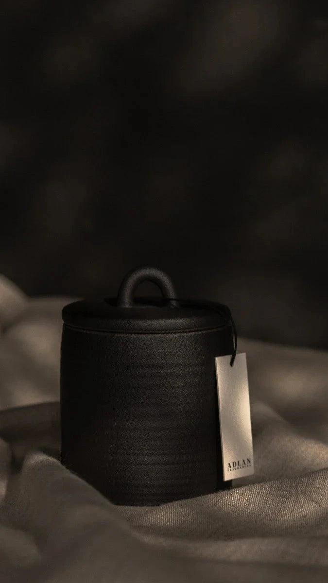 Black woven basket with a tag on a textured surface