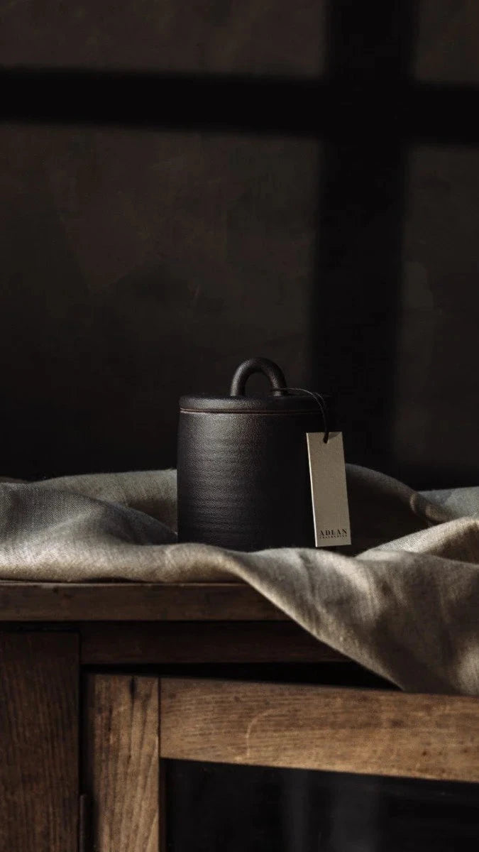 Dark wooden container on a textured surface with a dark background