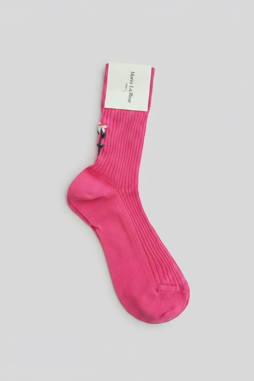 Pink sock with floral design on a wooden surface