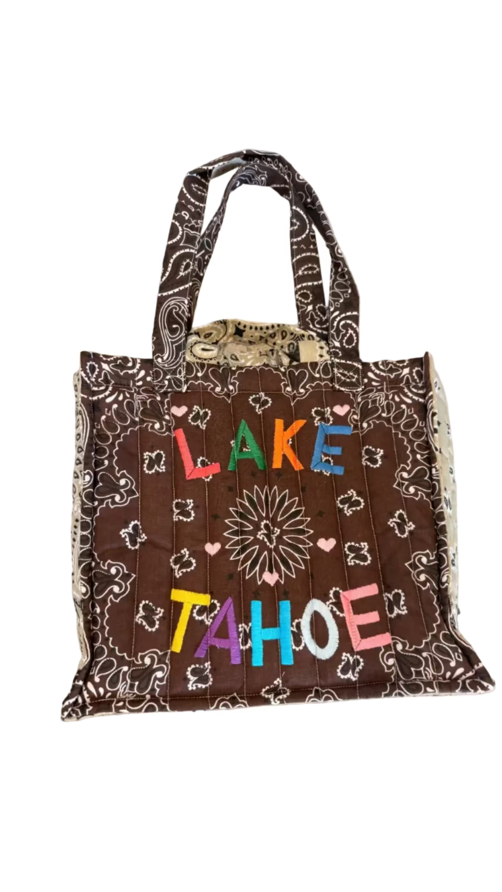 Brown bag with 'Lake Tahoe' text on a concrete surface