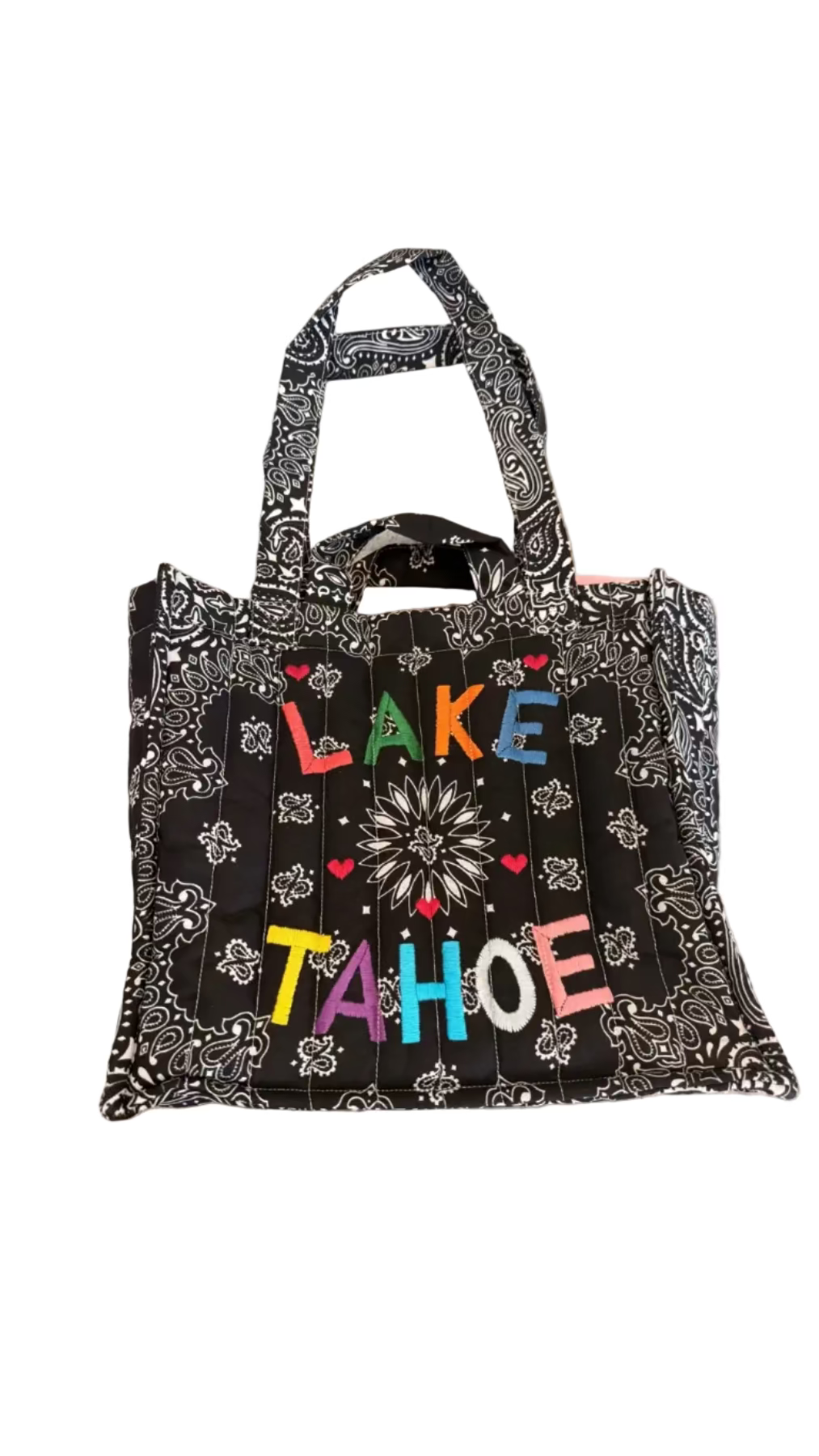 Black patterned tote bag with 'Lake Tahoe' text on a beige surface