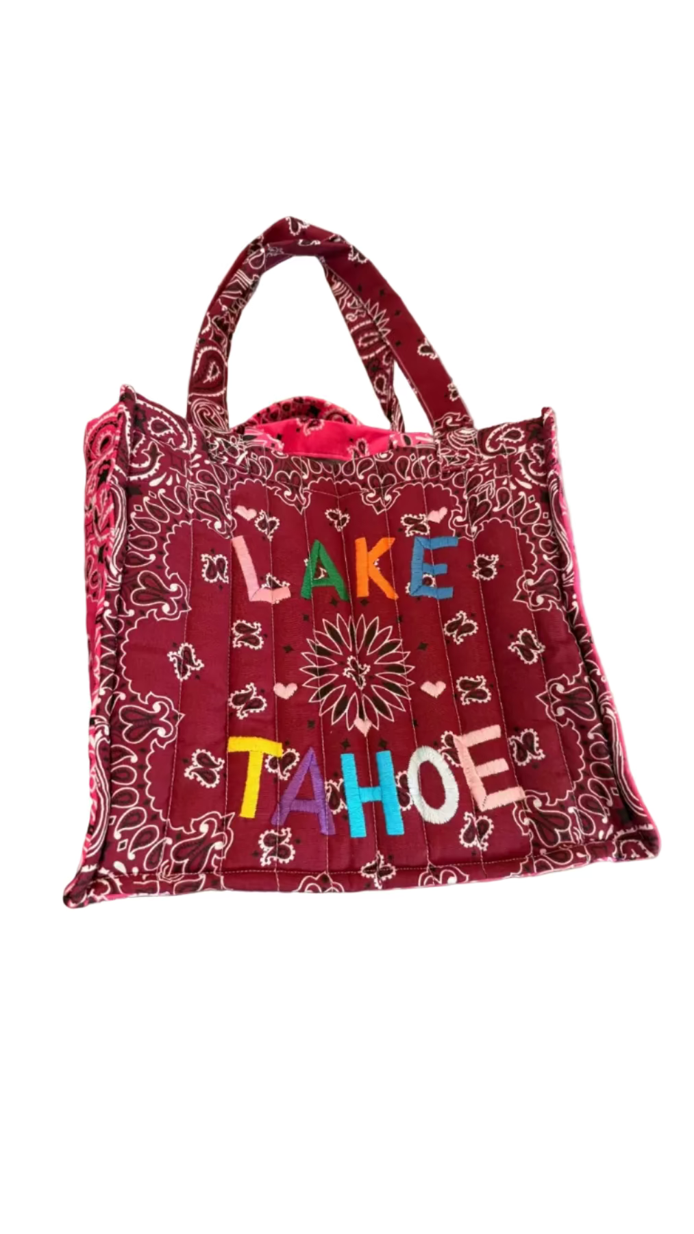Red bandana-patterned tote bag with 'Lake Tahoe' text on a concrete surface