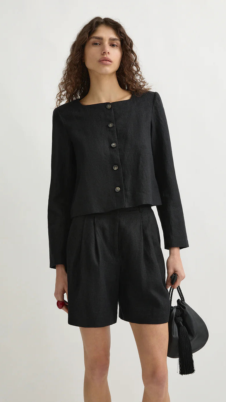 Woman wearing a black outfit with a jacket and shorts on a white background