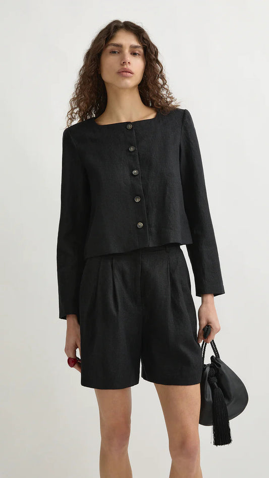 Woman wearing a black outfit with a jacket and shorts on a white background